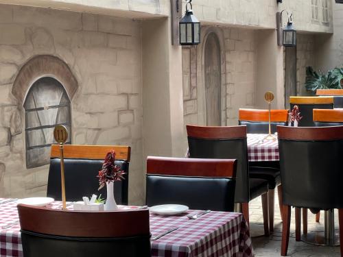 a dining room with tables and chairs and a stone wall at Lotus by Serendib in Blantyre