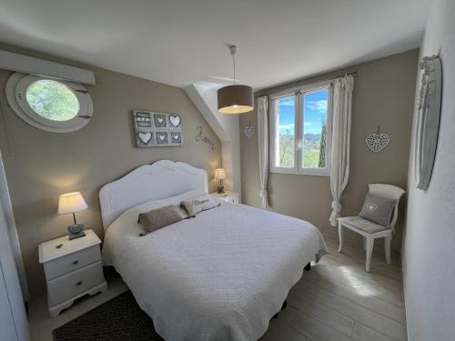 une chambre avec un lit blanc et une chaise dans l'établissement Villa bella 8 personnes, à Fayence