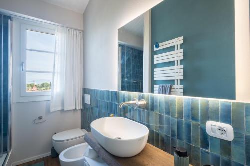 a bathroom with a sink and a toilet and a mirror at Villetta Marice by VacaVilla in Stabbia