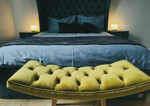 a bedroom with a large bed with a yellow ottoman at Valmiera Riverside Retreat - Beverina Secret in Ķeiži
