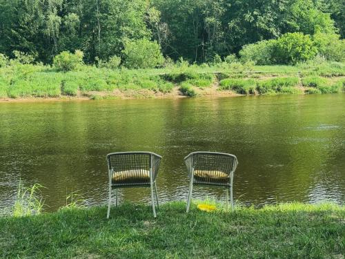 dos sillas sentadas en medio de un río en Valmiera Riverside Retreat - Beverina Secret, 