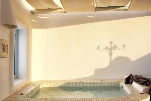 a swimming pool in a room with a cross on the wall at Dreams Luxury Suites in Imerovigli