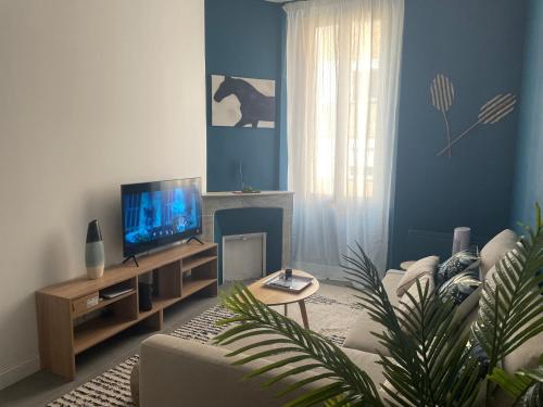 un salon avec un canapé et une télévision dans l'établissement Le contemporain - Golfe Juan - 5 min des plages - 10 min de Cannes!, à Vallauris