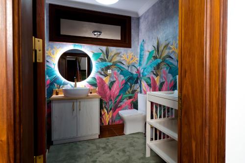 a bathroom with a sink and a mural of flowers at Villa Maria Caetana in Frazão