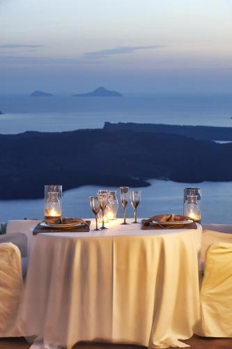 a table with wine glasses and lights on it at Dreams Luxury Suites in Imerovigli
