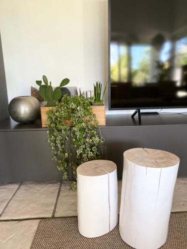 two white stools in a living room with plants at Jesolo Beach Villa in Lido di Jesolo