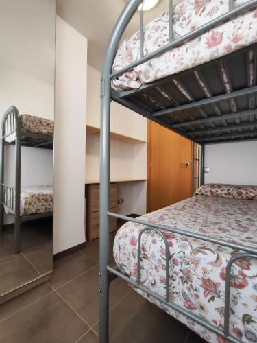 a bedroom with two bunk beds and a desk at La Barcassa de Deltebre in Deltebre