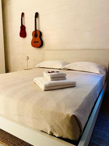 a bedroom with a bed with two guitars on the wall at Jesolo Beach Villa in Lido di Jesolo