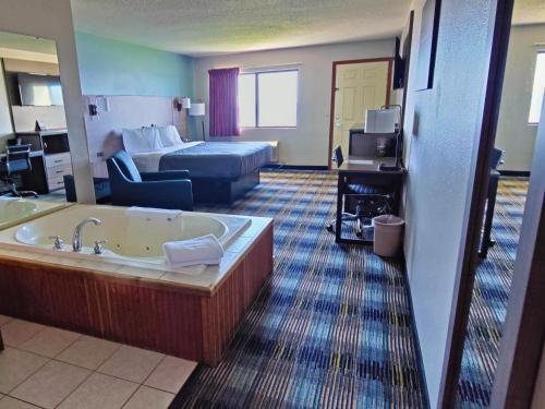 a hotel room with a tub and a bed at Bavarian Haus Lakefront Inn in Saint Ignace