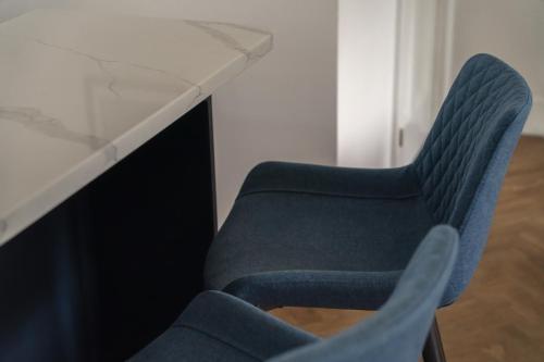 a blue chair sitting next to a glass table at Crossriggs- Beautiful Detached Home in Windermere