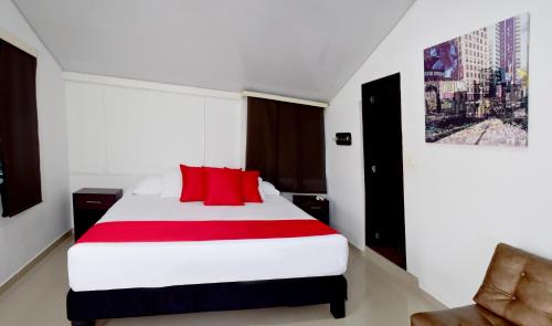 a bedroom with a red and white bed and a chair at Finca Hotel Palmas Del Edén in Armenia