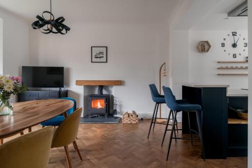 a living room with a table and a wood stove at Crossriggs- Beautiful Detached Home in Windermere