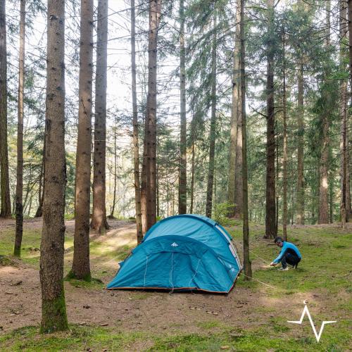 a blue tent in the middle of a forest at Placàt Eco Camping nel bosco in Bossico