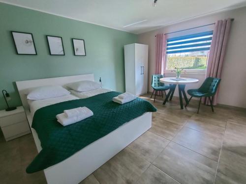 1 dormitorio con 1 cama, mesa y sillas en APartament Piaskowa en Gniewino