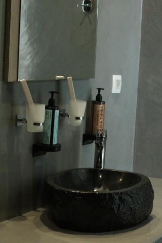 a bathroom with a sink and a mirror at Serenità Luxury Suites in Akrotiri