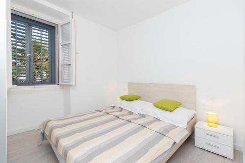 - une chambre blanche avec un lit et une fenêtre dans l'établissement 2 bedrooms apartement at Zadar 500 m away from the beach with city view balcony and wifi, à Zadar
