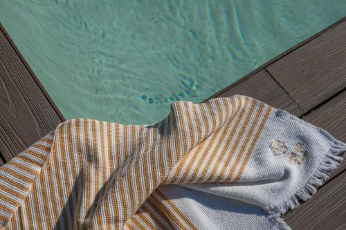 a robe sitting on a table next to a swimming pool at Masseria Li Foggi in Gallipoli