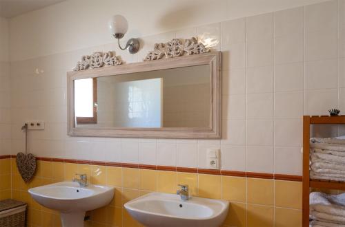 a bathroom with two sinks and a mirror at Le Bariole, luxury villa with heated pool in Cesseras