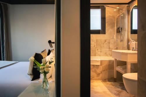 a bathroom with a vase of flowers on a table at Hôtel le Derby Alma by Inwood Hotels in Paris