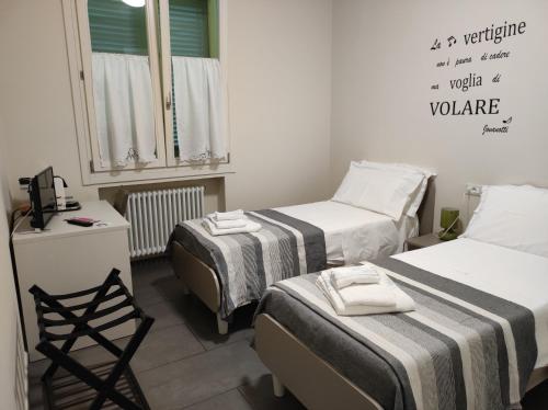 ein Zimmer mit 2 Betten und einem Stuhl darin in der Unterkunft Braschi 8 B&B in Zola Predosa