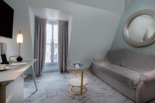 a living room with a couch and a table at Hôtel le Derby Alma by Inwood Hotels in Paris