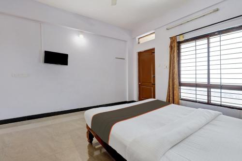 Habitación blanca con cama y ventana en Collection O KMM Kushi Resort, en Gundlupet