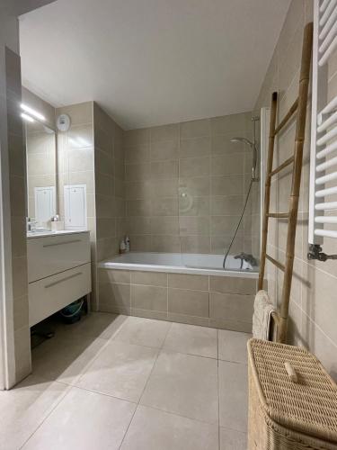 une salle de bain avec une baignoire et un lavabo dans l'établissement Modern family 3 bedroom apartment in the center of Maisons-Laffitte, à Maisons-Laffitte