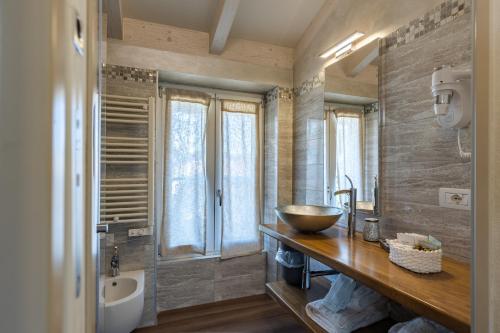 a bathroom with a bowl sink on a wooden counter at Villa Vitali - Bellagio in Bellagio
