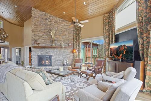 a living room with a brick fireplace and white furniture at Pipers Paradise in Beech Mountain
