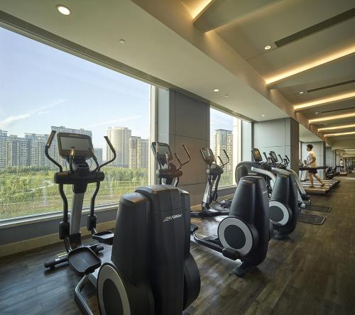 a gym with a row of treadmills and exercise bikes at Shangri-La Tangshan in Tangshan