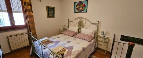 a bedroom with a metal bed with pillows on it at "A Ridosso" sul mare nel cuore del paese in Le Grazie