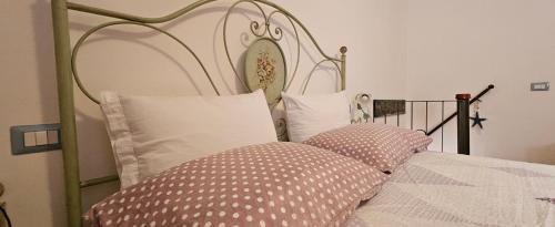 a bed with polka dot pillows on it at "A Ridosso" sul mare nel cuore del paese in Le Grazie