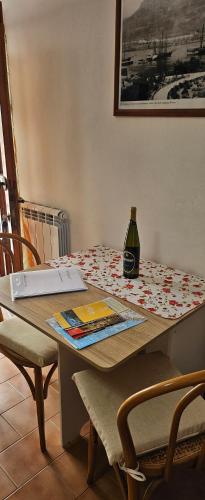 a table with a laptop and a bottle on it at "A Ridosso" sul mare nel cuore del paese in Le Grazie
