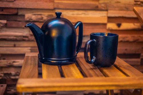 a black tea kettle and a cup on a table at Arnlod's nest in Kotlje