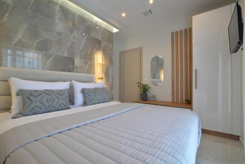 sypialnia z dużym białym łóżkiem z niebieskimi poduszkami w obiekcie Irida Apartments w mieście Leptokaria