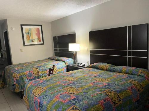 a hotel room with two beds and a lamp at Deerfield Inn in Xenia