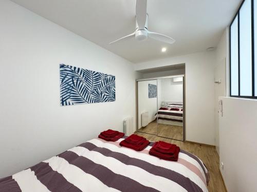 Un dormitorio con una cama con toallas rojas. en Appartement 1ch avec terrasse et jardinet à 400m de la plage, en Cavalaire-sur-Mer