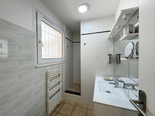 baño blanco con lavabo y ventana en Appartement 1ch avec terrasse et jardinet à 400m de la plage, en Cavalaire-sur-Mer