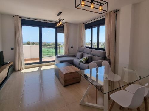 a living room with a couch and a glass table at Toyo Alcazaba Suites Gran terraza y vistas, 2Hab, piscina y garaje in Retamar