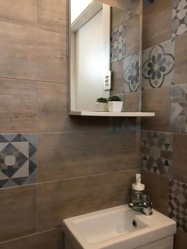 a bathroom with a sink and a mirror at Monolocale a Lesa - monolocale indipendente con divano letto e angolo cottura in Lesa