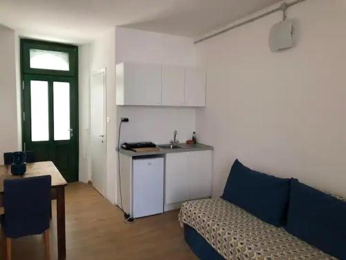 a living room with a couch and a kitchen at Monolocale a Lesa - monolocale indipendente con divano letto e angolo cottura in Lesa