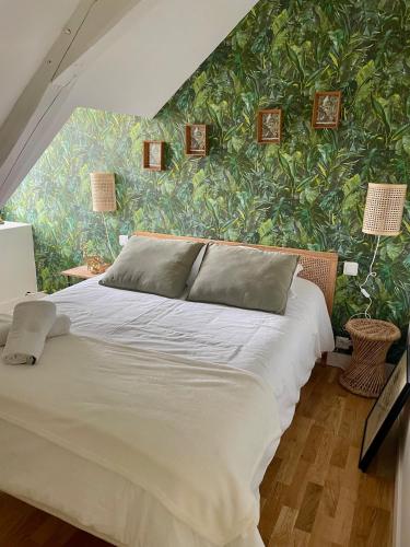 une chambre avec un grand lit et un mur végétal dans l'établissement Chez Gus - 10 personnes - BCLA, à Arnage