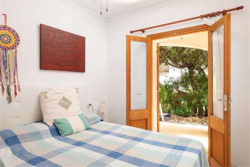 a bedroom with a bed and an open door at La Casa del Far in Alcanada