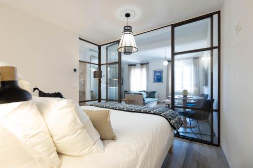 Un dormitorio con una cama blanca y una sala de estar. en SAINTE ANNE by Time Off Collection, en Saint-Tropez