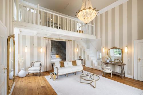 a living room with a couch and chairs and a chandelier at Schloss Hertefeld & Hertefeldhof in Weeze