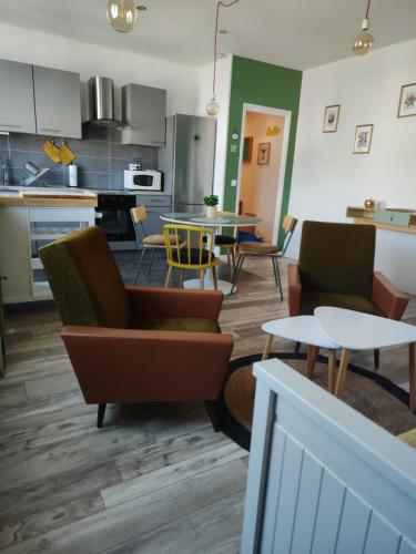 a kitchen and living room with chairs and a table at Gîte, le Colmar Vintage Station in Colmar