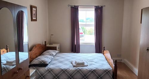 a bedroom with two beds and a window at Glencolumbkille House - Self Catering Rooms in Glencolumbkille