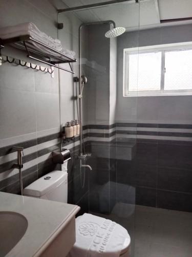 a bathroom with a toilet and a glass shower at Rockmila Hotel in Phu Quoc