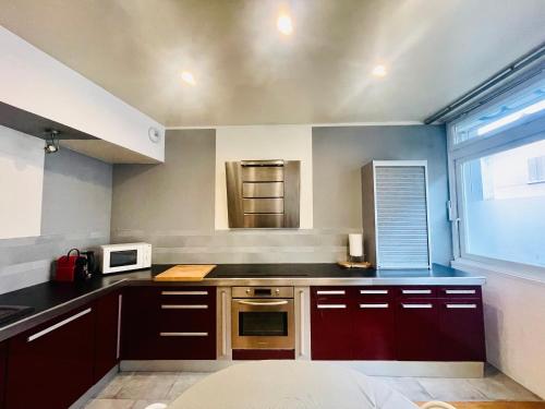 - une cuisine avec des placards bruns et un four micro-ondes dans l'établissement Le Loft de l Abbe, à Grenoble