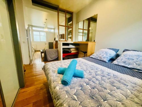 une chambre avec un lit avec des oreillers bleus dessus dans l'établissement Le Loft de l Abbe, à Grenoble